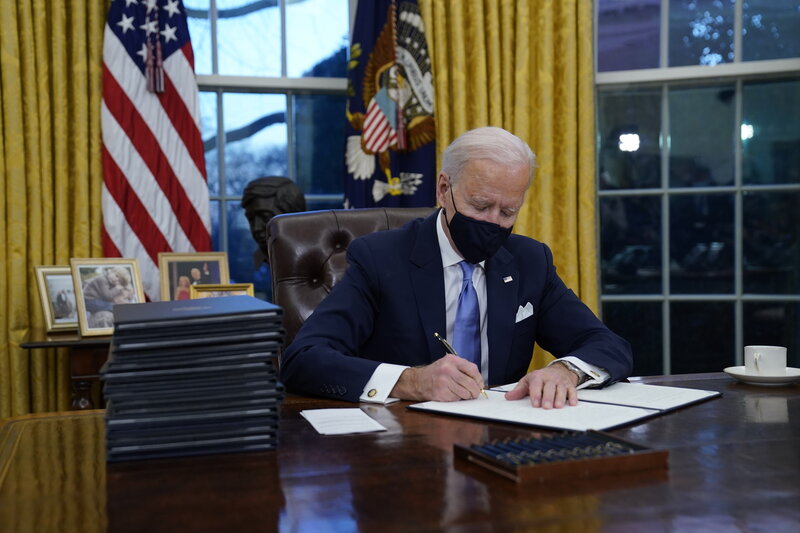 President Joe Biden signs his first executive orders in the Oval Office