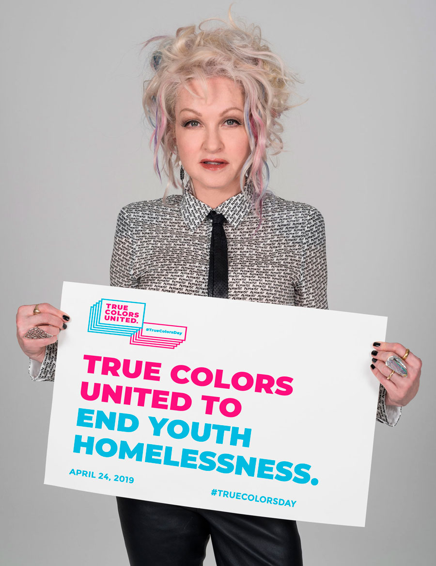 Cyndi Lauper holds a sign that says, 